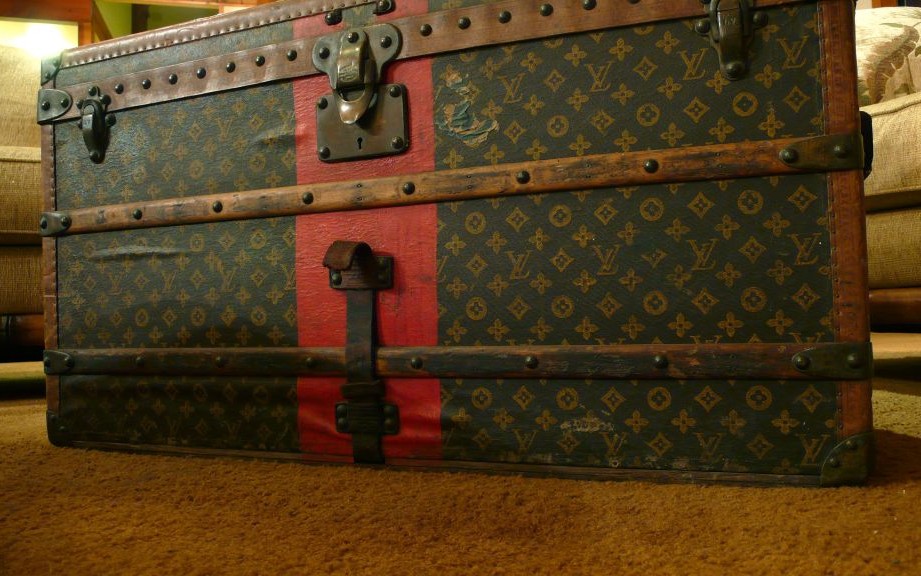 Visitors take photos of a suitcase on display during the Louis